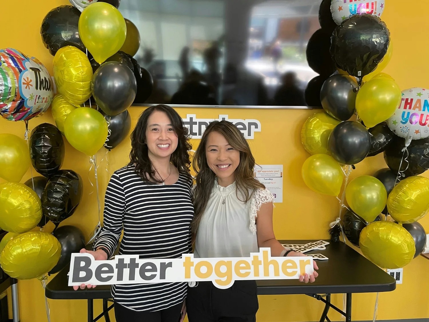 A group of people holding a sign saying Better Together